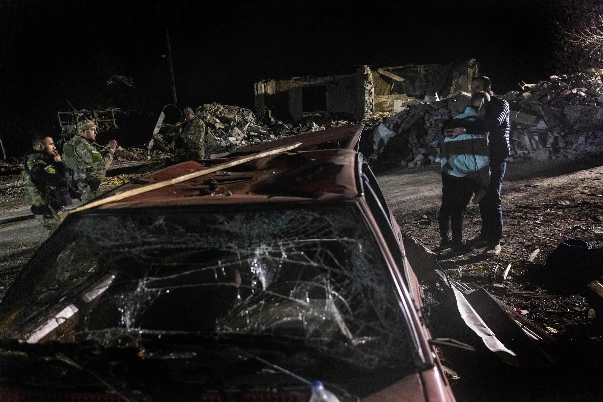 Поки українські військові та поліція шукали жертв удару, жінку втішав її чоловік, поки вони чекали на новини про родича